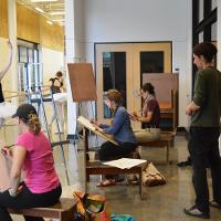 Ballerinas posing while students sketch them 