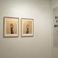 An exhibit called "Every Five Minutes": a matched pair of paintings, one of a left hand, one of right, each with fingers outstretched 
