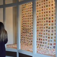 A woman next to a case containing many small photos and slides