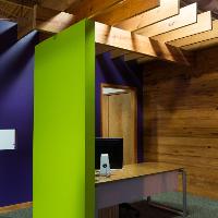 A colorful reception desk with wood beams, blue and neon-green walls 