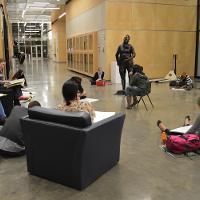 Students relaxing in big black chairs or on the floor 