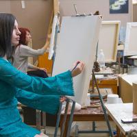 Two female students at their easels 