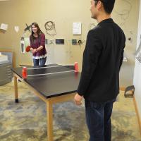 A professor and a student playing ping pong 