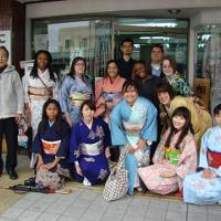 Students and several Asian women in kimonos, posing 