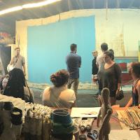 A panorama of people in a large art studio 