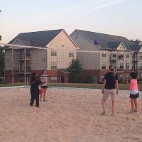 Four campers play volleyball together outside of the Courtyard dorms.