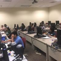 a computer lab with a number of students working on computers