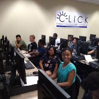 a computer lab with a number of students, some looking at the camera
