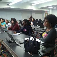 several students sitting in a classroom with long tables