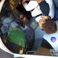 a female student sitting in a simulation cockpit, looking at the screen