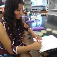 a female student sitting and taking notes in a notebook