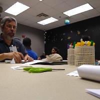 a male student looking at papers on a table