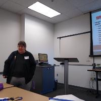 a person standing in front of a presentation talking to an audience
