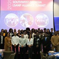 several people posing on a stage looking at the camera