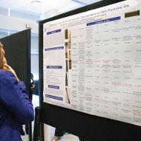 a woman in a blue shirt looking at a presentation