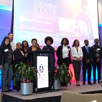 several people posing on a stage looking to the side