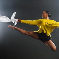 a female student in a yellow sweater soaring through the air.
