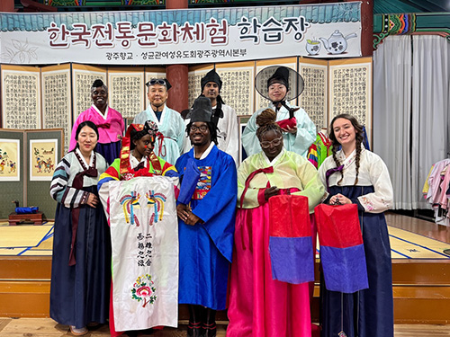 several people posing on a stage dressed in traditional clothes