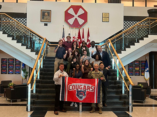 several people standing on a staircase with a CSU banner