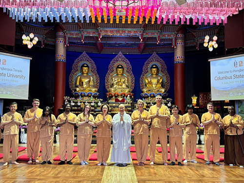 several people posing in front of large statues