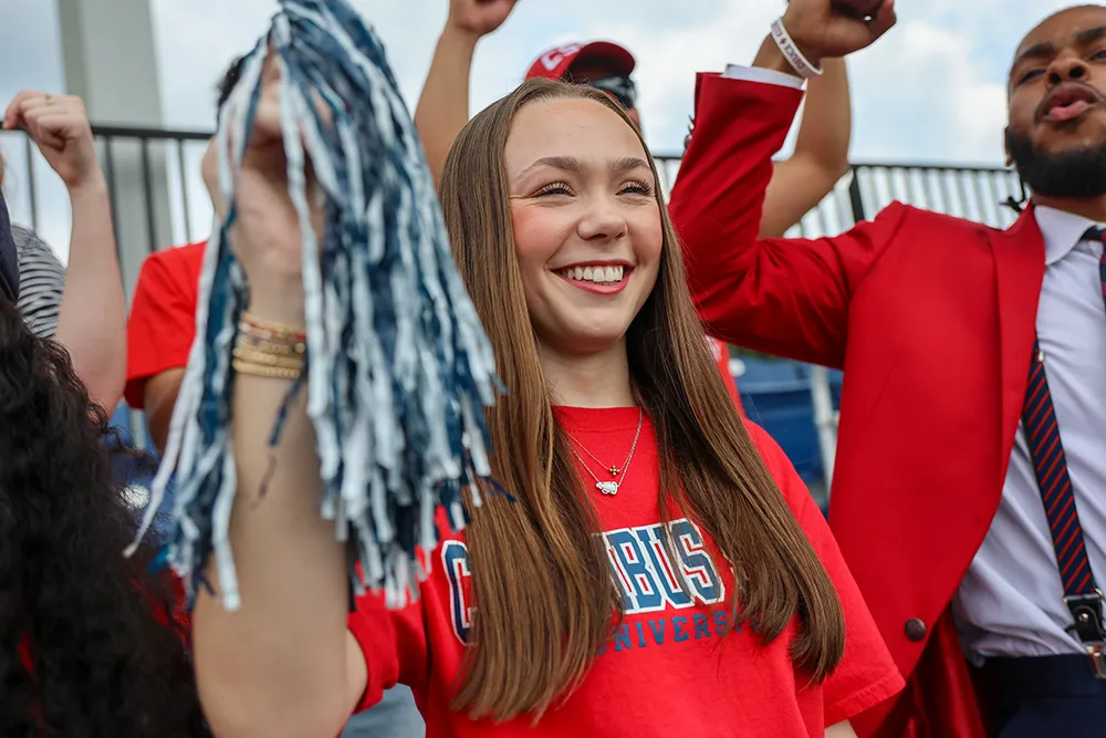 A girl and her classmates cheering at an athletics event