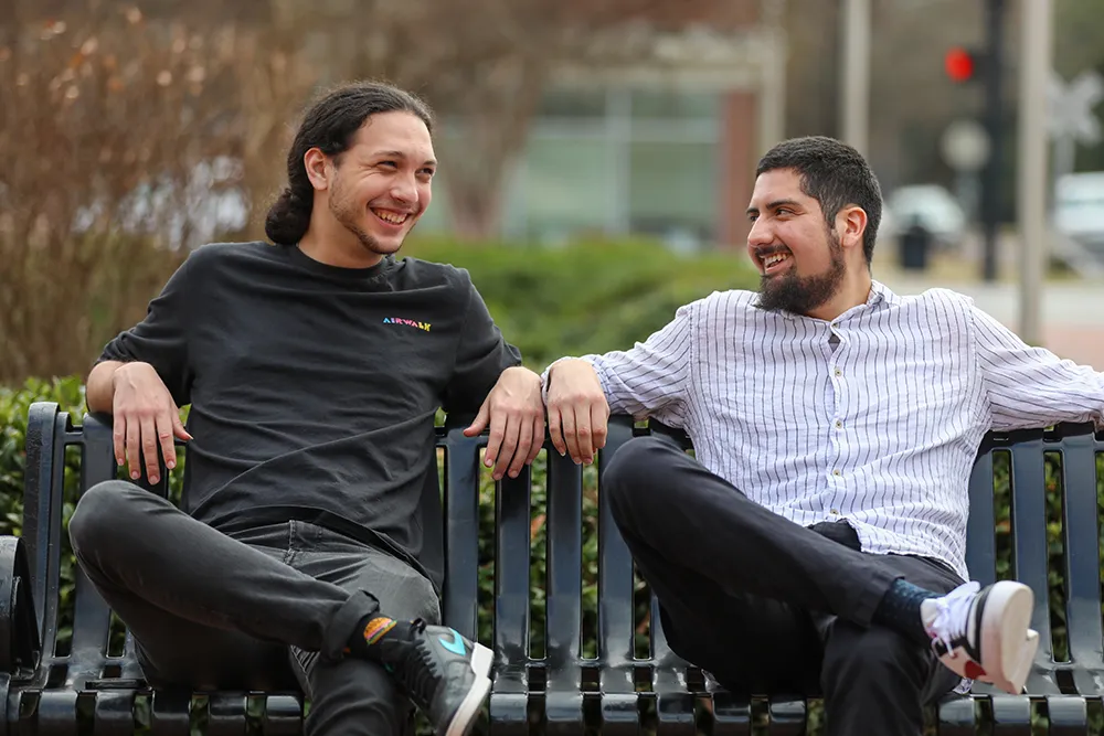 Two honors college students smiling and talking with each other