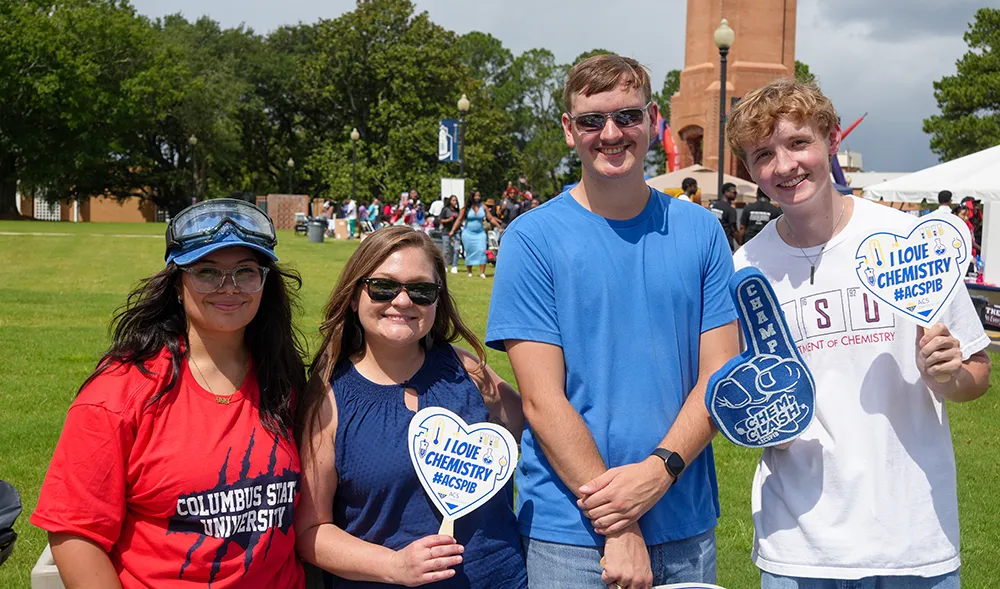 Students smiling at the camera, representing their different organizations.