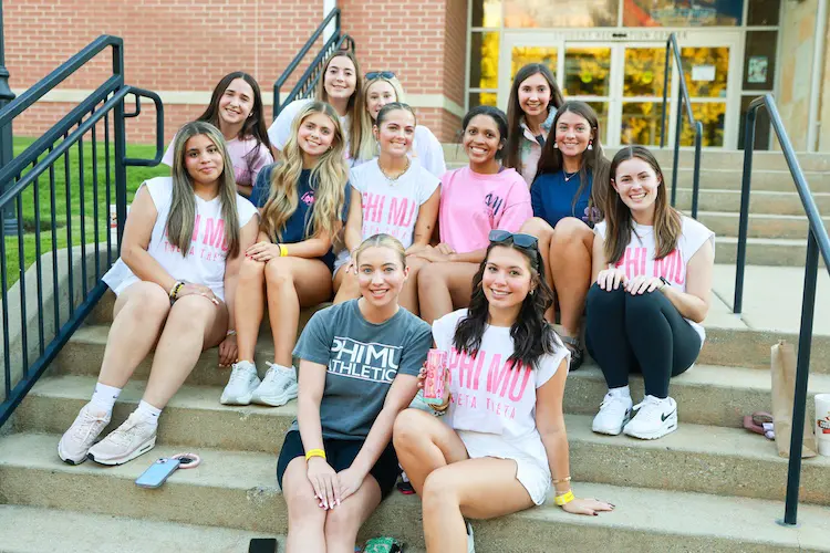 Group of Phi Mu sorority students posing on the steps in front of campus rec center