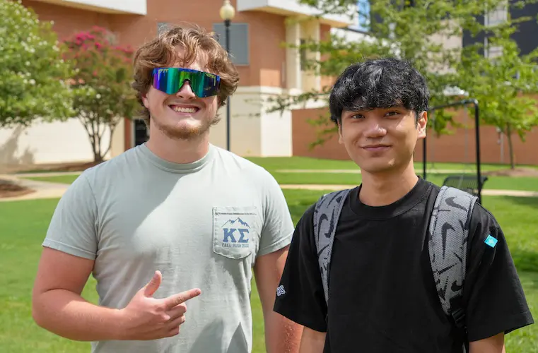 Two fraternity students posing outside of the Davidson Center