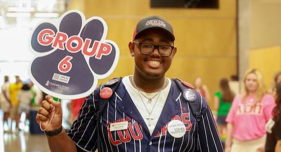 student volunteer holding an orientation sign