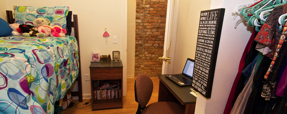 bedroom with a lofted bed, a nightstand, and a desk and chair