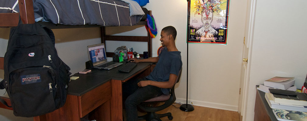 student on laptop in bedroom