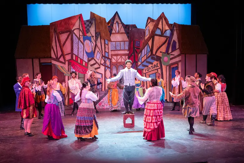 students circled around one student standing up on a box during a play