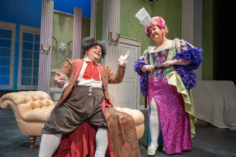 a make and female student on stage performing in colorful attire