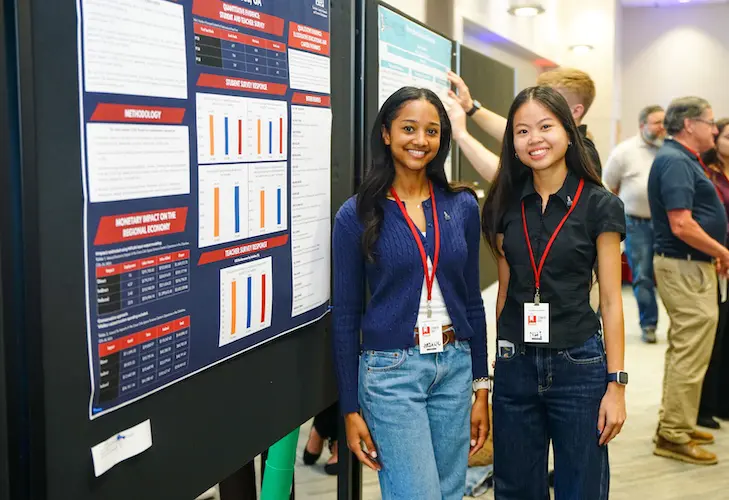 Jordan Mills and Nhi Do standing with their presentation poster at Tower Day 2026