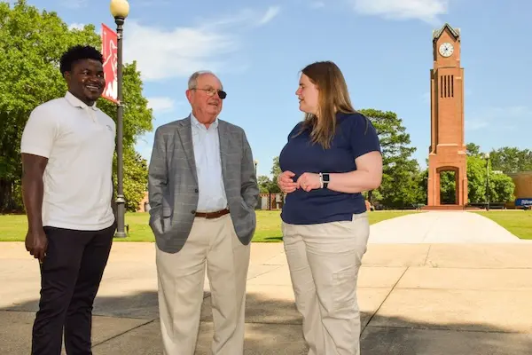 Steve Butler talking with 2 students on campus