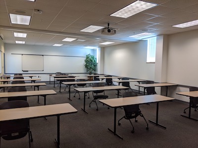 Classroom from rear, two-person desks and a whiteboard