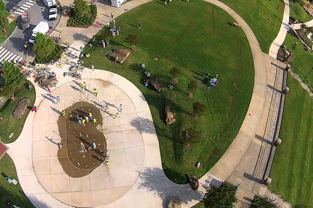 an aerial shot of a park with a number of people walking around